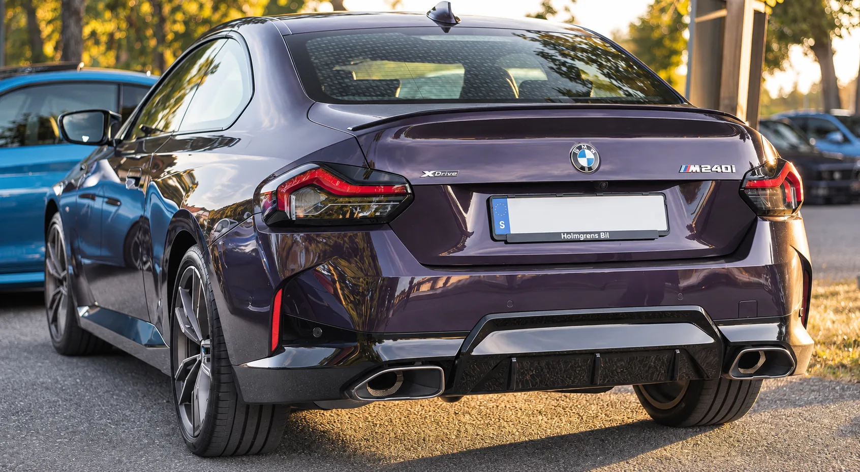 Mörklila BMW på bilträff vid Brostugan på Kärsön i kvällssol.